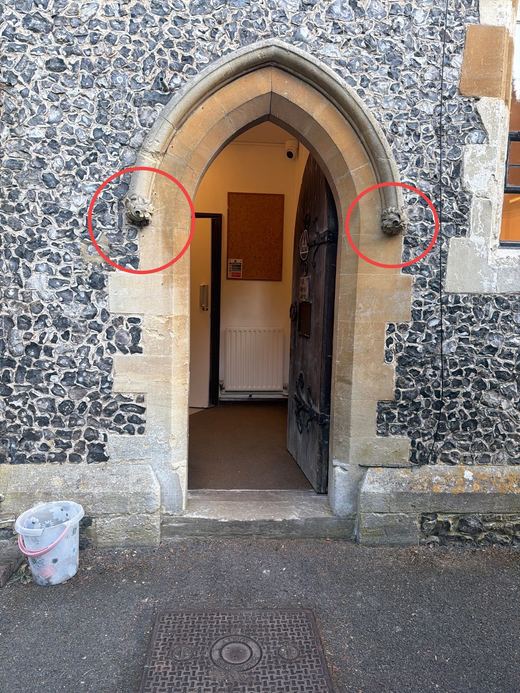 Church doorway with two damaged stone corbels circled in red